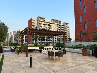 a pavilion with a table and chairs and some buildings at Modern 2BR with Balcony in Azizi Riviera 23 in Dubai
