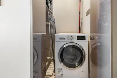 a laundry room with a washing machine and a washer at Stylish 1-Bedroom Apartment at DAMAC Paramount in Dubai