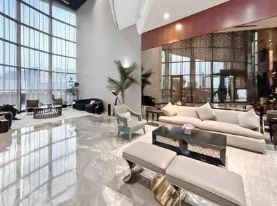 a living room with white furniture and large windows at Stylish 1-Bedroom Apartment at DAMAC Paramount in Dubai