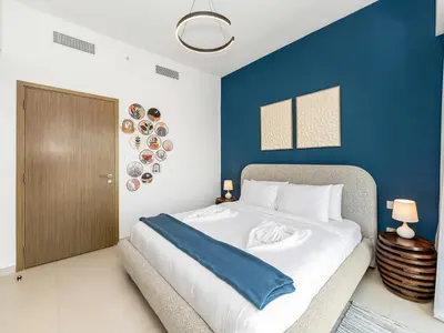 a bedroom with a large bed with a blue wall at Burj Royale 1BD Apartment 5mins walk to Dubai Mall and Burj Khalifa in Dubai
