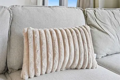 a beige couch with two pillows on it at Incredible Family Townhouse Villa I Sleeps 10 in Dubai