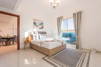 a bedroom with a bed and a dining room at Family-Friendly Apartment, Few Minutes Drive to Dubai Marina, Miracle Garden and Mall of the Emirates - Elite Residences 4, Sports City by Deluxe Holiday Homes in Dubai