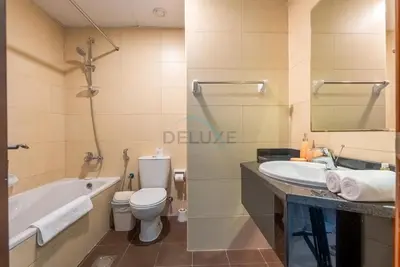 a bathroom with a tub and a toilet and a sink at Family-Friendly Apartment, Few Minutes Drive to Dubai Marina, Miracle Garden and Mall of the Emirates - Elite Residences 4, Sports City by Deluxe Holiday Homes in Dubai