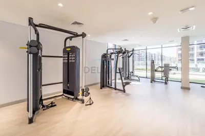 a gym with several treadmills and exercise bikes at Cozy 1BR, Easy Access to Dubai Mall - Azizi Riviera 36 by Deluxe Holiday Homes in Dubai