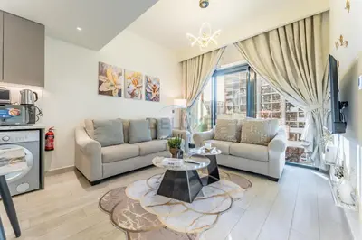 a living room with a couch and a table at Cozy 1BR, Easy Access to Dubai Mall - Azizi Riviera 36 by Deluxe Holiday Homes in Dubai