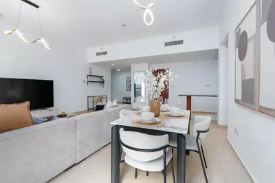 a dining room and living room with a table and chairs at White Sage JBR Sadaf Large 1BR on High Floor with two balconies in Dubai