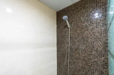 a bathroom with a shower with a tile wall at White Sage JBR Sadaf Large 1BR on High Floor with two balconies in Dubai