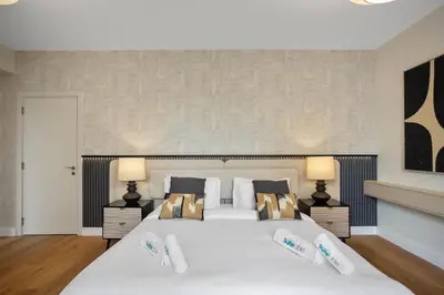 a bedroom with a large white bed with two lamps at Designer 2Bedroom in Rimal near to JBR Beach in Dubai