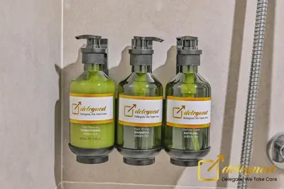 three bottles of green liquid in a box at Modern Comfort Studio DAMAC Hills 1 in Dubai