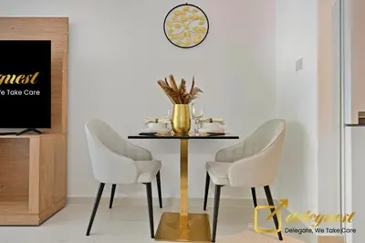a dining room with a table and two chairs at Modern Comfort Studio DAMAC Hills 1 in Dubai