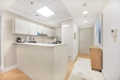 an empty kitchen with white cabinets and a counter at ShoresInn - Sleek & Modern Stay at Dubai Marina in Dubai
