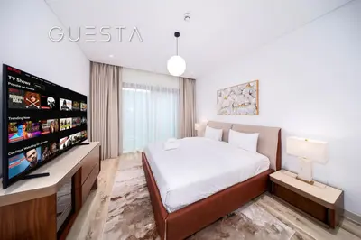 a bedroom with a bed and a flat screen tv at Myrtle Central Park, City Walk Dubai in Dubai