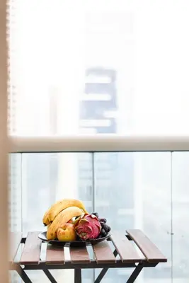a plate of food on a table next to a window at FiveX Luxury 2BR at Lake Point JLT in Dubai