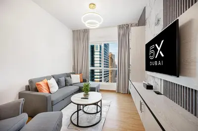 a living room with a couch and a tv at FiveX Luxury 2BR at Lake Point JLT in Dubai