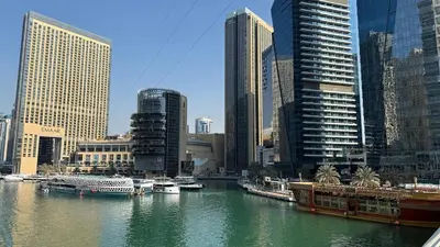 a river with boats in a city with tall buildings at Luxury 2BR Huge New Apartment in Dubai
