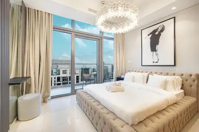 a bedroom with a large bed with a chandelier at Luxe 3BR with Infinity Pool and Burj Khalifa View l High Floor in Dubai