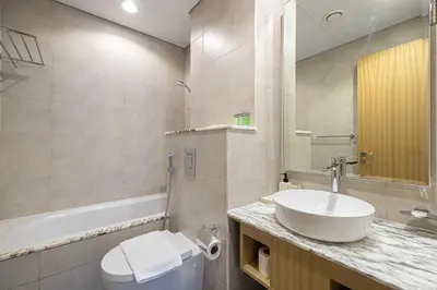 a bathroom with a sink and a toilet and a tub at Luxe 3BR with Infinity Pool and Burj Khalifa View l High Floor in Dubai