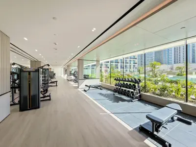 an office building with a gym with benches and windows at Modern Studio in Prime JVC Padel, Pool & Gym in Dubai