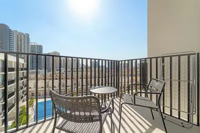 a balcony with chairs and a table and a view at Modern Studio in Prime JVC Padel, Pool & Gym in Dubai