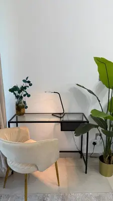 a desk and a chair in a room with plants at Huge Studio DMCC Metro Close to Marina in Dubai