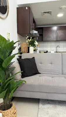 a living room with a couch and a kitchen at Huge Studio DMCC Metro Close to Marina in Dubai