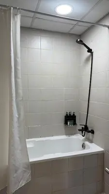 a bath tub in a bathroom with a shower at Huge Studio DMCC Metro Close to Marina in Dubai