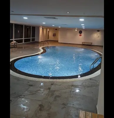 a large swimming pool in a large building at Huge Studio DMCC Metro Close to Marina in Dubai