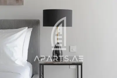 a table with a lamp on it next to a bed at 2BR Address JBR - Direct Beach Access & Top Views in Dubai