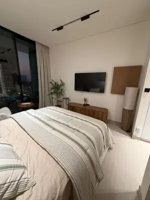 a bedroom with a bed and a flat screen tv at Luxury 1BR Binghatti JVC in Dubai