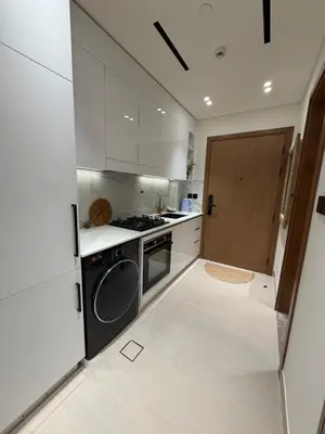a kitchen with white cabinets and a stove and a door at Luxury 1BR Binghatti JVC in Dubai