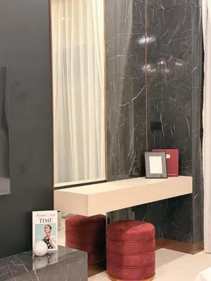 a bathroom with a mirror and a table with red stools at HYDE WALK STUDiO BURj ViEW & PREMiUM COMFORt in Dubai