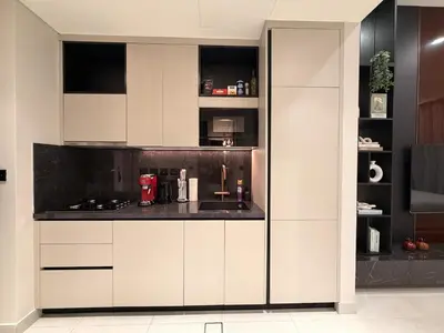 a kitchen with white cabinets and a counter at HYDE WALK STUDiO BURj ViEW & PREMiUM COMFORt in Dubai