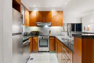 a kitchen with wooden cabinets and stainless steel appliances at DIFC 1 Bed, City View, 600m to Metro, Sleeps 4 in Dubai