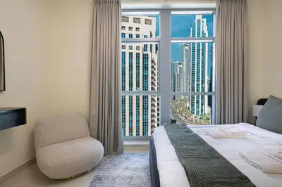 a bedroom with a bed and a chair and a window at Chic 1BR near Burj Khalifa - Downtown in Dubai
