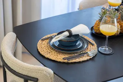 a black table with a plate of food and a glass of orange juice at Chic 1BR near Burj Khalifa - Downtown in Dubai