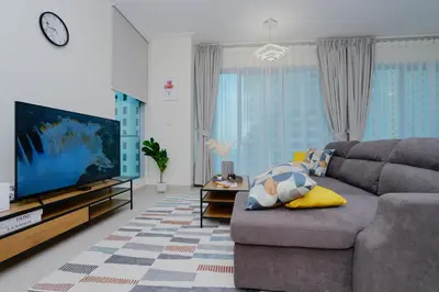 a living room with a couch and a flat screen tv at Bright 1BR Marina Promenade Partial Sea View in Dubai