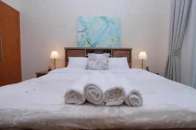 a bedroom with a white bed with towels on it at Bright 1BR Marina Promenade Partial Sea View in Dubai