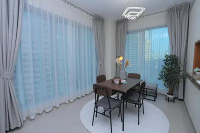 a dining room with a table and chairs and large windows at Bright 1BR Marina Promenade Partial Sea View in Dubai