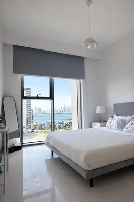 a white bedroom with a bed and a large window at Creek Harbour Home Burj Khalifa Downtown View in Dubai