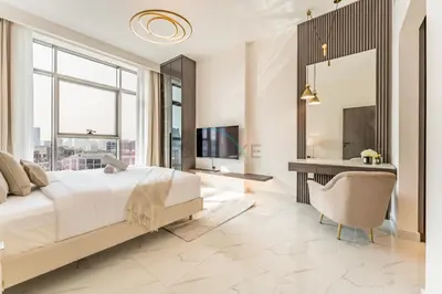 a bedroom with a bed and a desk and a mirror at Perfectly Positioned Near Dubai Miracle Garden and Butterfly Garden, Quick Drive to Global Village, Adhara Star, Arjan by Deluxe Holiday Homes in Dubai