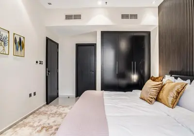 a bedroom with a large white bed with gold pillows at Two Bedroom Apartment at JBR with Marina and Bluewaters Views in Dubai