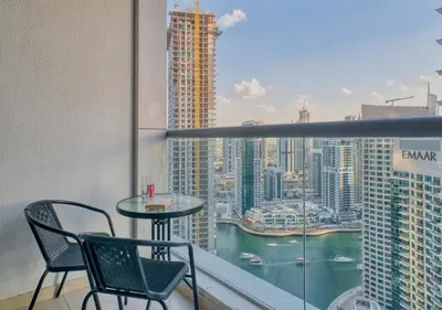a balcony with a table and chairs and a view of a city at Two Bedroom Apartment at JBR with Marina and Bluewaters Views in Dubai