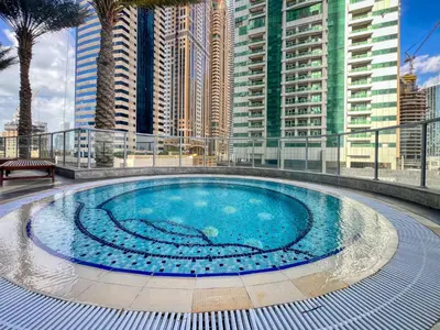 a large swimming pool on a building with tall buildings at Stylish Large 2BR Apartment in the Heart of Dubai Marina in Dubai