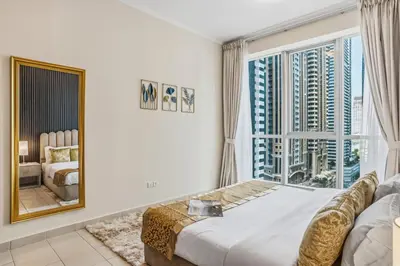 a bedroom with a bed and a large window at Stylish Large 2BR Apartment in the Heart of Dubai Marina in Dubai