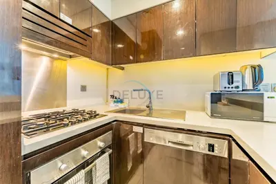 a kitchen with a stove and a sink at Chic 2BR Apartment, Near Dubai Mall and Fountain - Damac Majestine, Business Bay by Deluxe Holiday Homes in Dubai