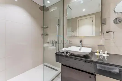 a bathroom with a sink and a shower at Chic 2BR Apartment, Near Dubai Mall and Fountain - Damac Majestine, Business Bay by Deluxe Holiday Homes in Dubai