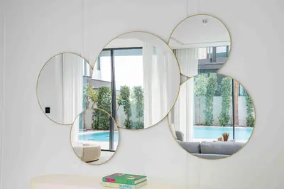 two mirrors on a wall with a couch in a living room at Frank Porter - Villa La Mer, Jumeirah 1 in Dubai