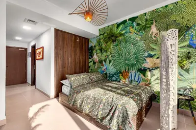 a bedroom with a bed with a tropical wallpaper at Waves - Nature-Inspired Studio - JLT Skyline Living in Dubai
