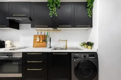 a kitchen with black cabinets and a dishwasher at Waves - Nature-Inspired Studio - JLT Skyline Living in Dubai