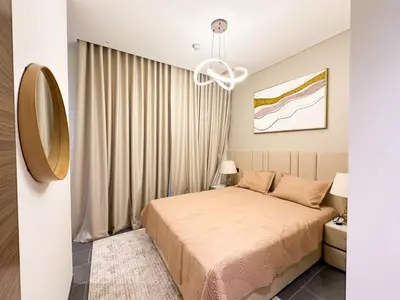 a bedroom with a bed and a chandelier at Stylish & Cozy Fully Furnished 2BR plus Maid Crest C in Dubai